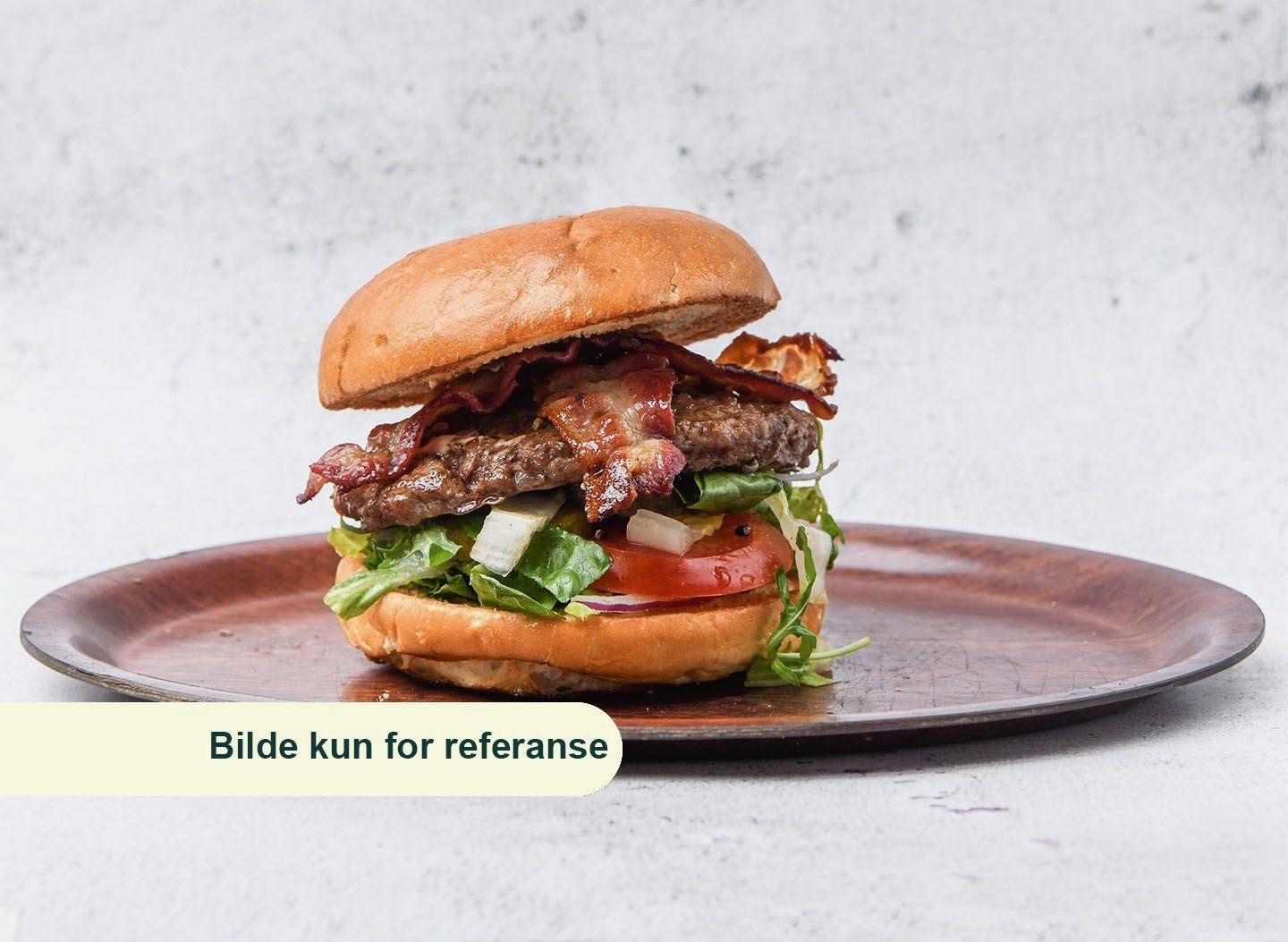 Saftig hamburger med bacon, salat, tomat og løk i en myk bolle, servert på en rustikk tallerken.