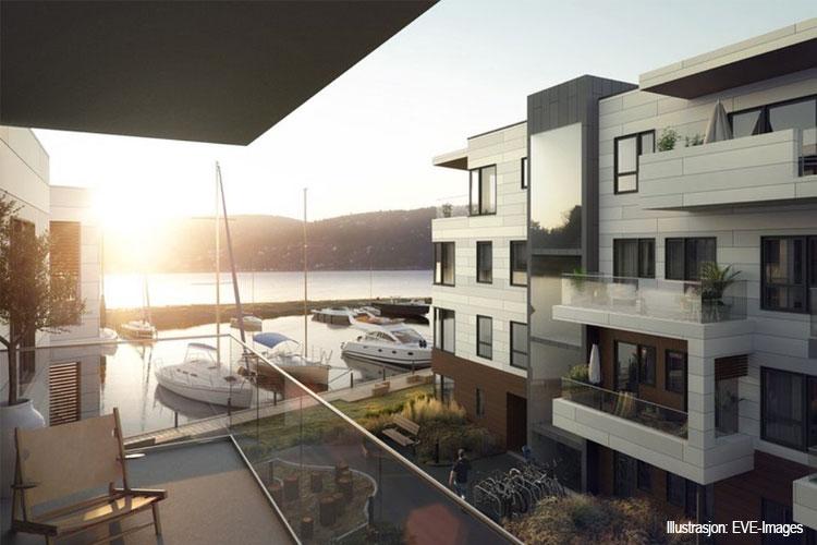 Moderne leiligheter med utsikt over havnen og båter, beliggende ved solnedgang.
