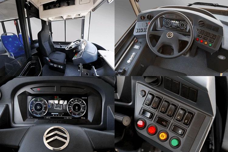 Interiør av en buss med førersete, dashbord og kontrollpanel med knapper og instrumenter.
