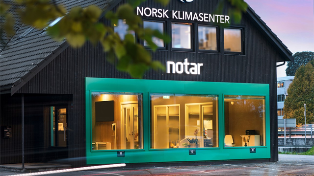 Norsk Klimasenter med grønne vinduer og moderne design, beliggende i et urbant område.