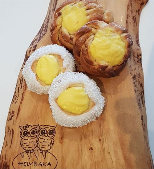 Boller med vaniljekrem og kokos, servert på en treplate med en dekorativ utskjæring.