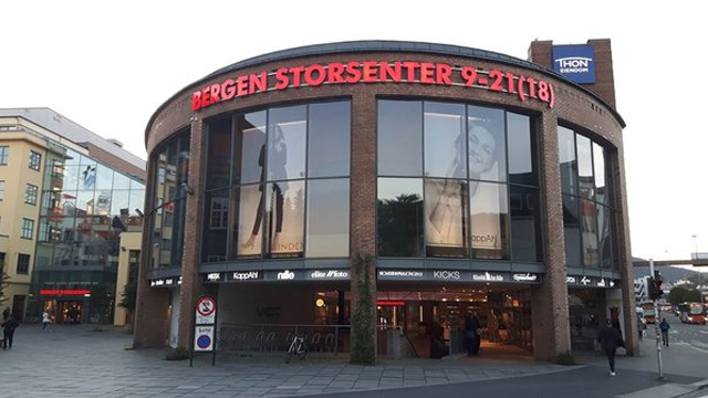 Bergen Storsenter med store vinduer og reklameplakater, beliggende i Bergen sentrum.
