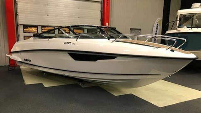 En moderne motorbåt av merket Pardo, modell 650 DC, utstilt i en båtbutikk med lys og romslig interiør.