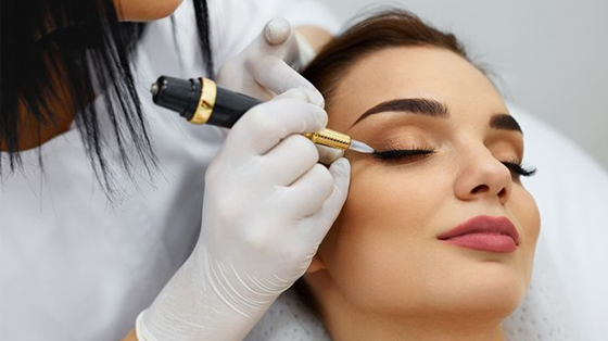 Kvinne får kosmetisk tatovering av eyeliner av en profesjonell behandler i et skjønnhetssalong.