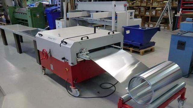 En metallbearbeidingsmaskin med rull av metallplater i en verkstedsetting.