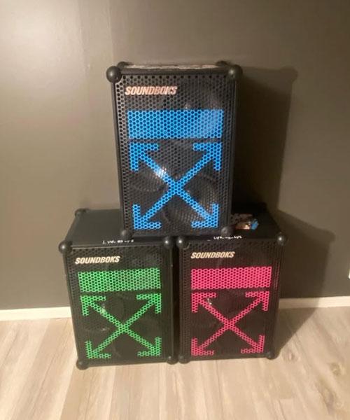 Tre fargerike høyttalere fra Sounddogs stablet oppå hverandre, med blå, grønn og rosa lysdesign.