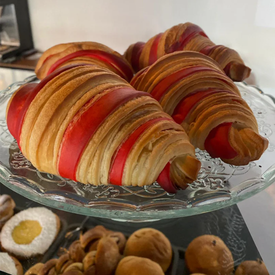 Flotte croissanter med rød og gyllenbrun farge, pent plassert på en glassfat.