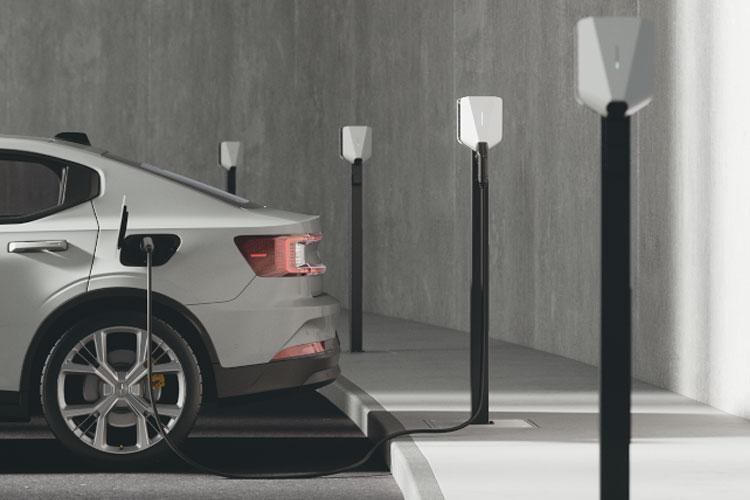 En elektrisk bil som lades ved en ladestasjon med flere ladestolper i en moderne parkeringsplass.