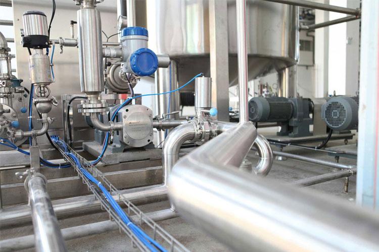 Industrielt rørledningssystem med pumper og ventiler i en moderne fabrikk.