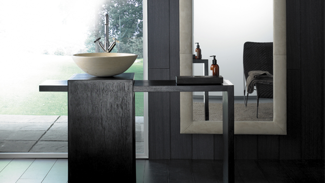 Moderne bad med en elegant servant, svart bord og stort speil i en stilren innredning.