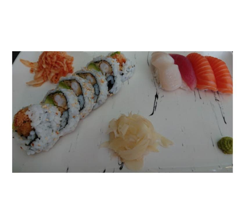 Sushi tallerken med maki, nigiri, ingefær og wasabi på en hvit tallerken.