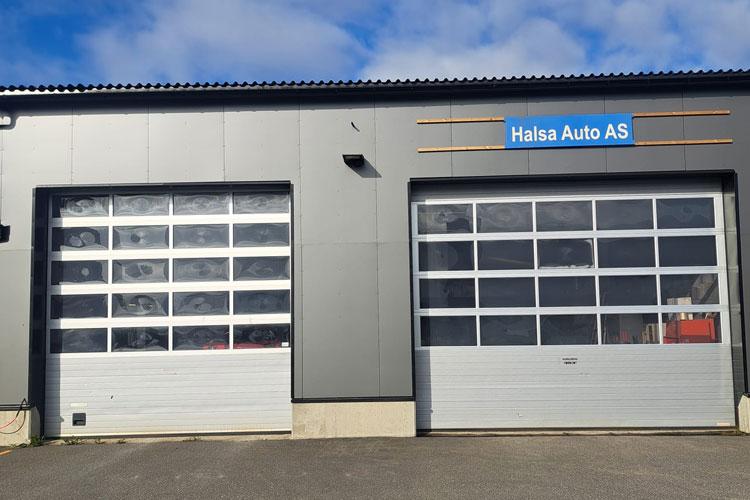 To store med garasjeporter til Halsa Auto AS under en blå himmel.