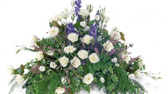 En vakker blomsteroppsats med hvite roser, lilla lupiner og grønt bladverk.