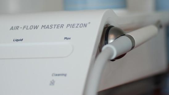 Nærbilde av Air-Flow Master Piezon med fokus på kontrollpanelet og slangen.