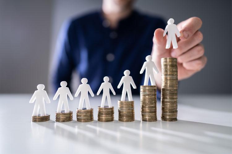 Papirfigurer i ulike høyder står på mynter, som symboliserer økonomisk vekst og investering.