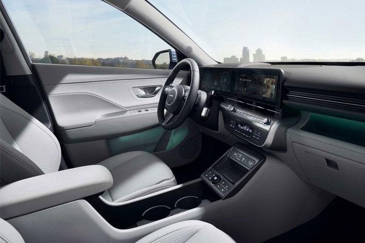 Interiør av en moderne bil med skinnseter, digitalt dashbord og panoramautsikt over byen.