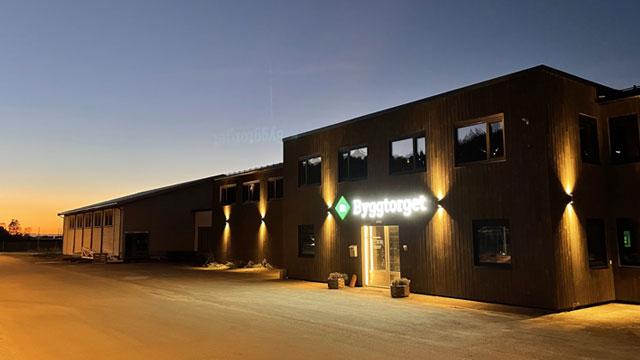 Moderne bygning med skiltet "Fordeltaget" opplyst ved solnedgang.