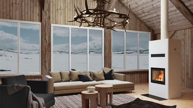 Moderne stue med peis, stor sofa, trebjelker og vinduer som viser snødekte fjell.