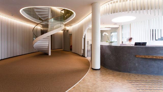 Moderne resepsjon med spiraltrapp, myke linjer og stilige detaljer i interiøret.
