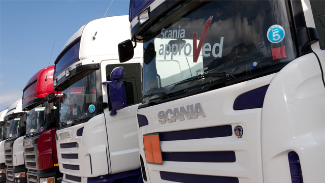 Flere lastebiler med Scania-logo, hvorav noen har "Scania approved" klistremerke på frontruten.