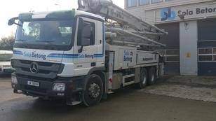 En lastebil fra Sala Betong med betongpumpe står parkert foran en bygning.