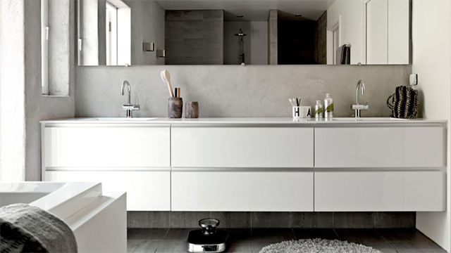 Moderne bad med hvit servantbenk, speil, dusj og minimalistisk innredning.
