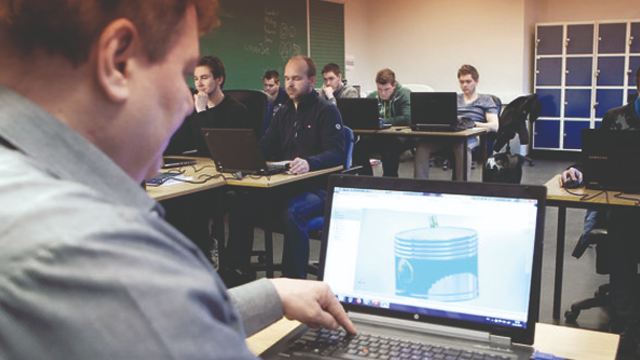 En lærer viser 3D-modellering på datamaskin til en gruppe studenter i et klasserom.