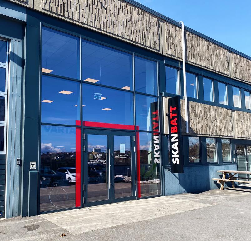 Inngangspartiet til Skanbatt med store vinduer og moderne fasade, beliggende i et industriområde.