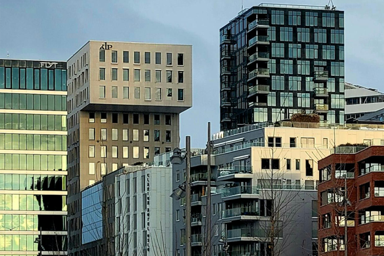 Moderne bygninger i en by med glassfasader og unike arkitektoniske detaljer.