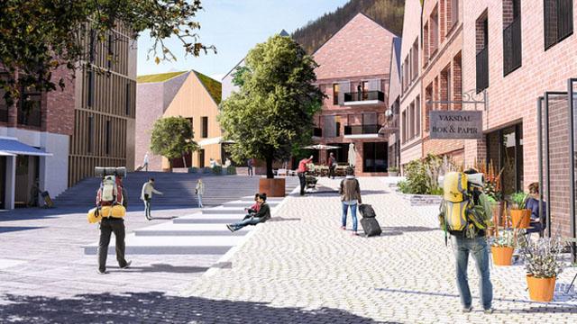 Moderne bymiljø med turister, kafeer og grønne trær i en koselig gate med brostein.
