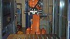 Industriell robotarm som arbeider i en produksjonslinje med metallkomponenter.