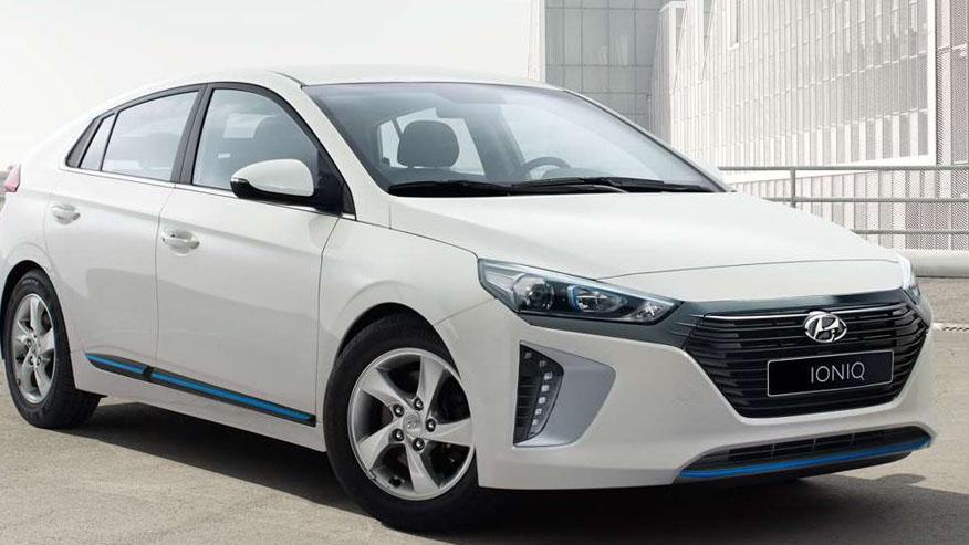 Hvit Hyundai Ioniq med moderne design parkert foran en bygning.