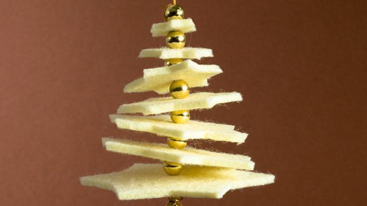 En dekorativ juletre laget av lag med lys filt og gullfargede perler.