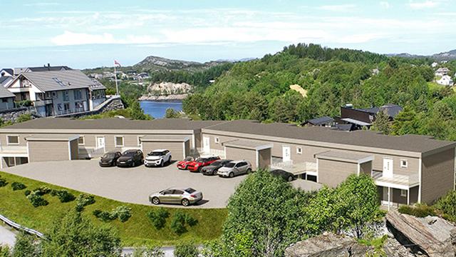Moderne boliger med parkeringsplass, omgitt av grønt landskap og utsikt over vannet.