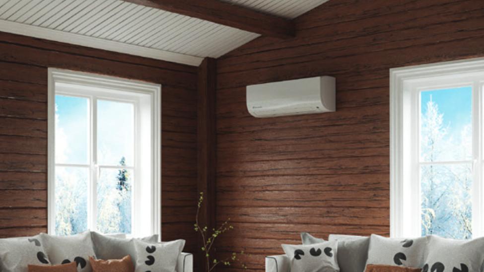 Lys stue med trevegger, hvite vinduer og en moderne klimaanlegg over en komfortabel sofa.