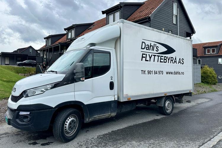 En flyttebil fra Dahl's Flyttebyrå AS parkert foran moderne hus.