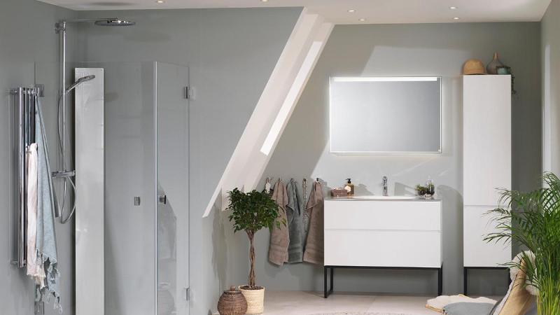 Moderne bad med dusj, hvite skap, speil og planter i et lyst rom med skråtak.