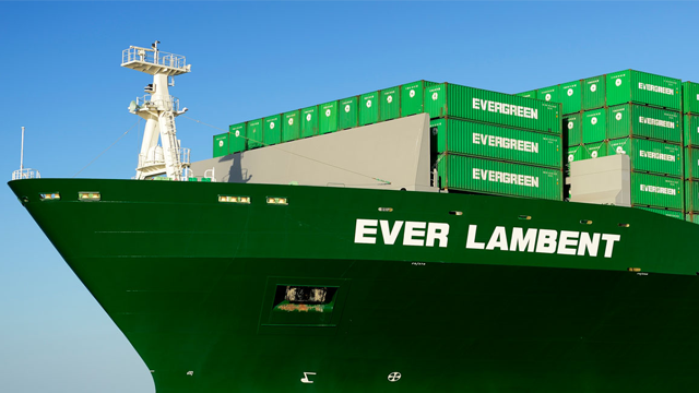 Containerfartøyet Ever Lambent med grønne containere i havn under klar himmel.