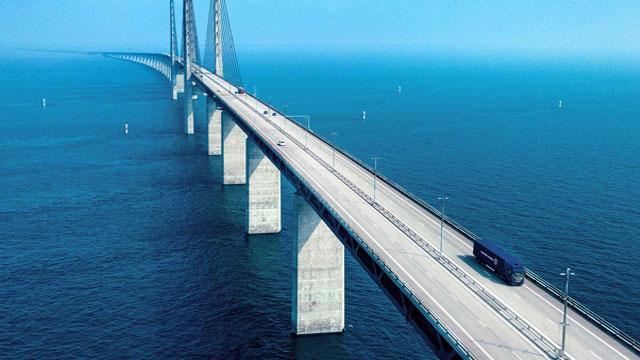 En oversiktsbilde av Øresundsbroen som strekker seg over havet med biler som kjører på veien.