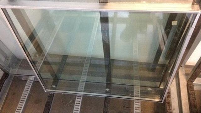 Et stort, klart glassvindu plassert på en metallramme i en bygning.
