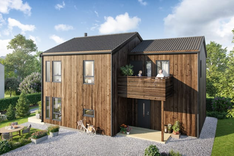 Moderne trehus med balkong, hage og uteplass, omgitt av grønt landskap og solfylt himmel.