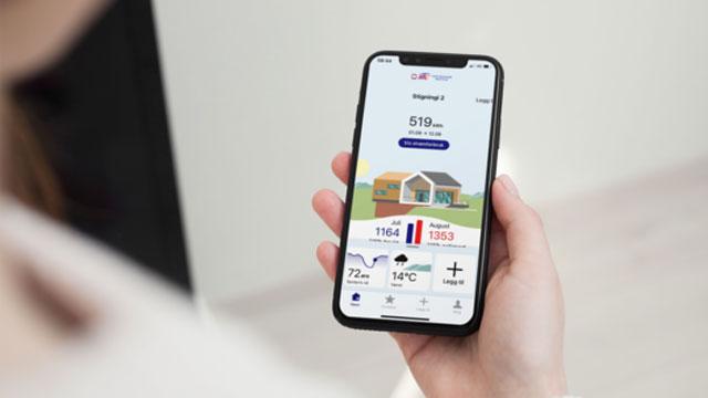 En person holder en smarttelefon som viser en app med værinformasjon og illustrasjoner av hus.