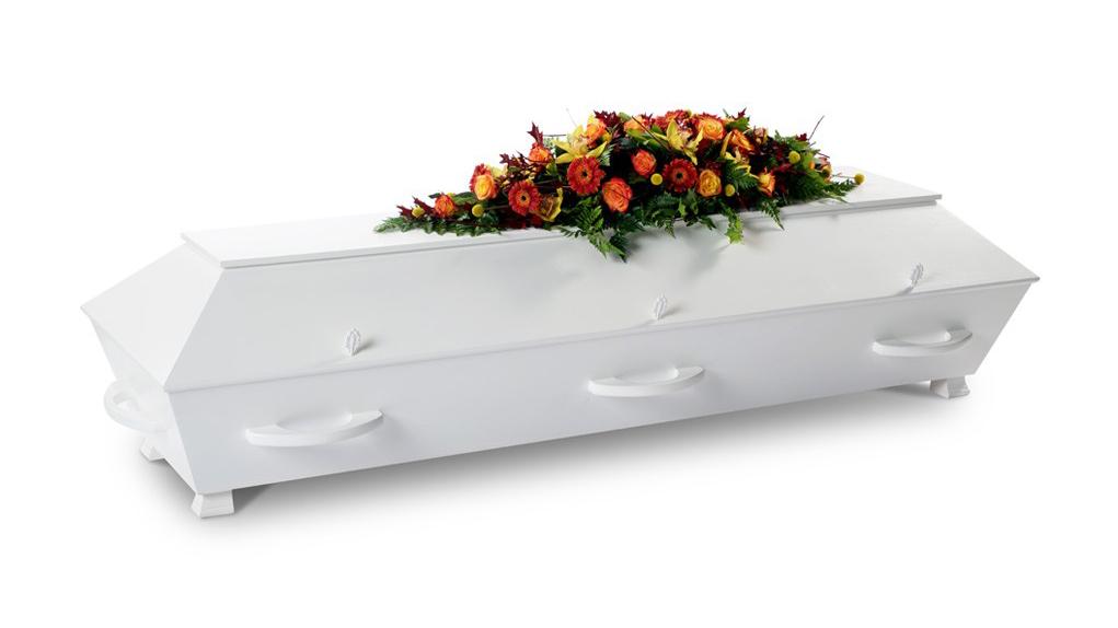 Hvit kiste med blomsterdekorasjon i varme farger på toppen, plassert på en lys bakgrunn.