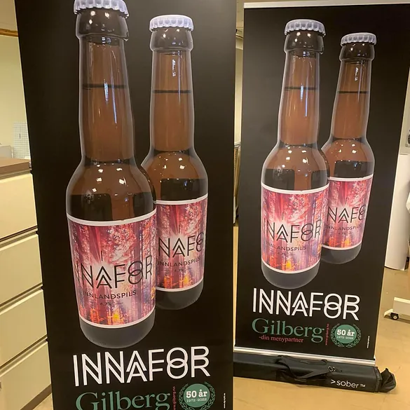To store med ølflasker med etikett som viser "INNAFOR" og "Gilberg", feirer 80-årsjubileum.