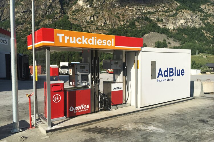 Diesel pumpe for lastebiler med AdBlue-stasjon i en bensinstasjon i fjellandskap.
