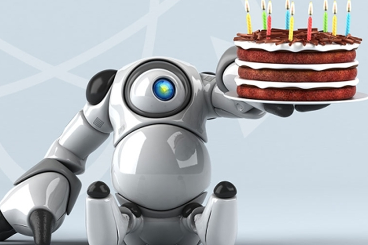 En robot holder en bursdagskake med lys på, med en lys blå bakgrunn.