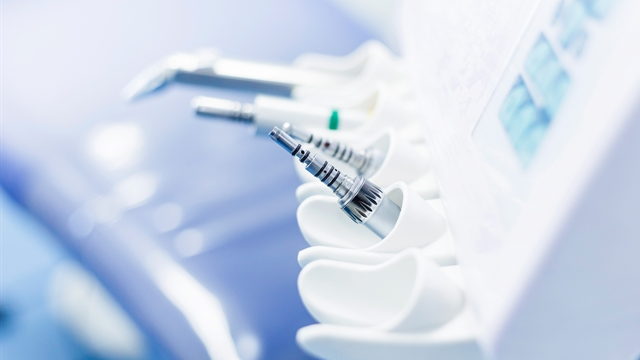 Dentalverktøy og utstyr på en moderne tannlegekontor, med fokus på instrumentene i forkant.
