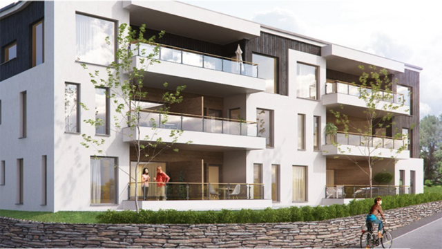 Moderne leilighetsbygg med balkonger, grønne planter og en syklist på fortauet.