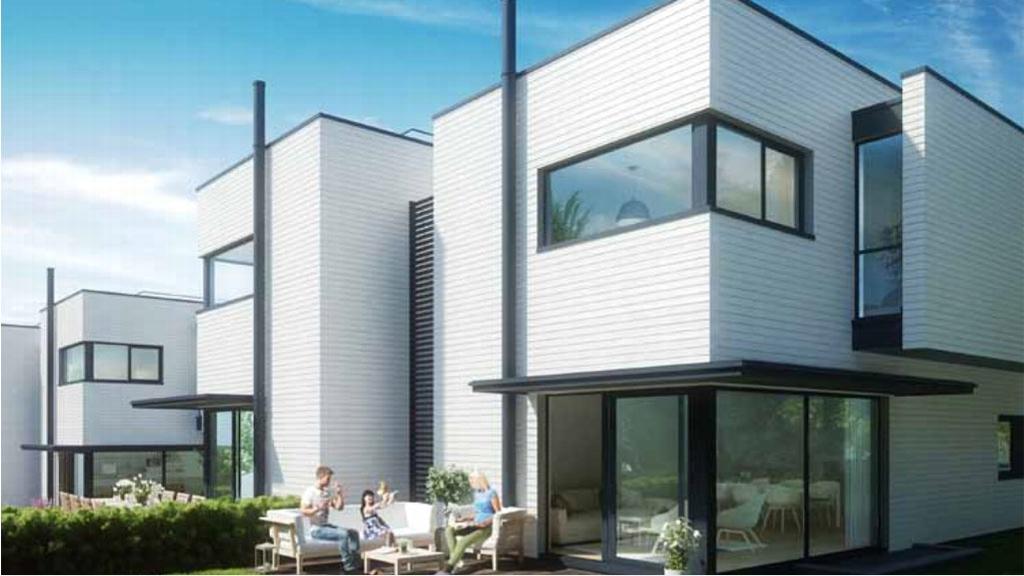 Moderne hus med hvite fasader og store vinduer, omgitt av grønt landskap og uteplass med sittegruppe.