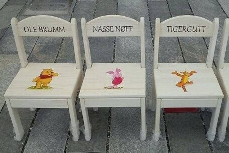 Tre barstoler med navnene Ole Brumm, Nasse Nøff og Tigergutt, dekorert med fargerike figurer.